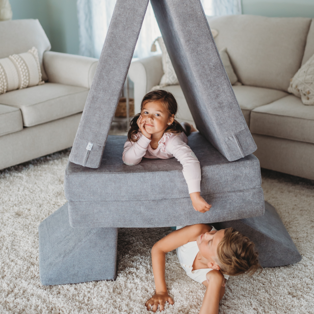 Two kids in a mattress fortress