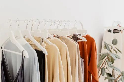 A rack full of Wearva brand apparel on white coat hangers