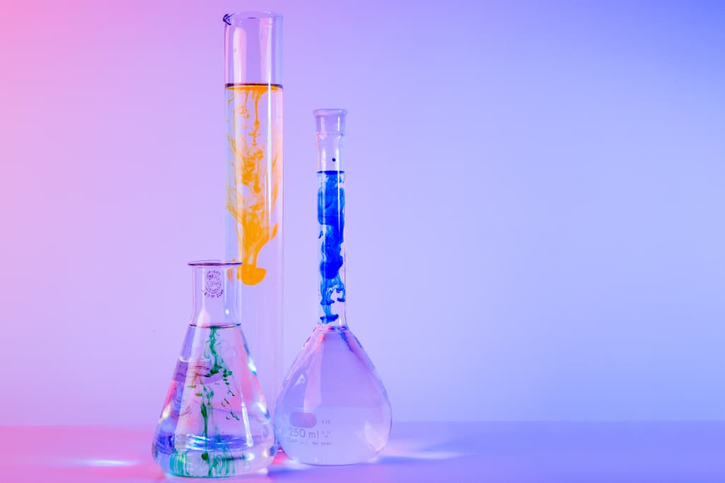 Test tube, conical flask and round-bottom flask with bright-colored chemicals inside